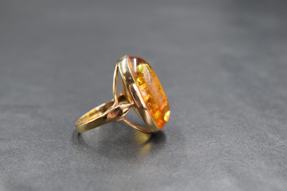 A 9ct gold amber set ring, the oval amber cabochon in a bezel setting having split shoulders, marked - Image 2 of 3