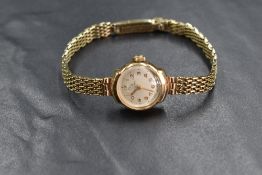 A 9ct gold Record wristwatch, the champagne dial having Arabic numerals, on a 9ct gold bracelet