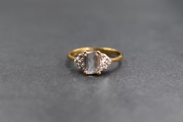 A 9ct gold cubic zirconia ring having a central emerald cut stone flanked by pave set small stones