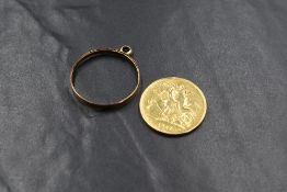 A high carat gold cast of a coin, tests as high carat gold, with a yellow metal mount, the cast