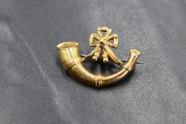 A yellow metal British Army Oxfordshire and Buckinghamshire Light Infantry brooch, having a bugle