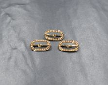 A group of three 14ct gold seed pearl set buckle brooches, marked 14k, 2cm x 1cm, 4.4g