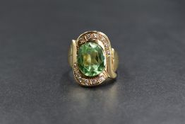 A 14ct gold paste and diamond set ring, the contemporary ring having a central oval cut green