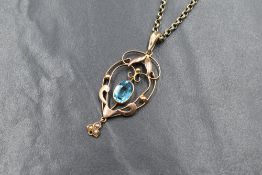 An Edwardian 15ct rose gold paste and pearl set pendant, the central oval cut blue paste in an