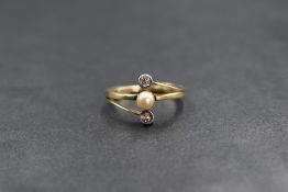 A yellow metal Artisan made seed pearl and diamond ring having a central pearl within crossover