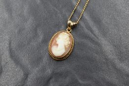 A 9ct gold cameo set pendant, the oval cameo having a maiden in profile in a bezel setting, marked