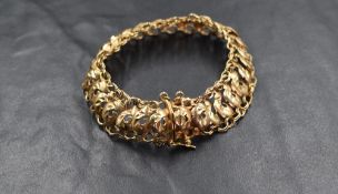 A 9ct gold fancy link bracelet, the foliate motif links having a curb style link border, marked