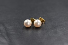 A pair of 18ct gold pearl studs, the cultured pearls of rounded form having a white-pink lustre,