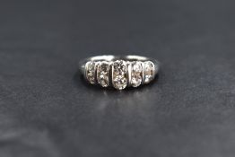 A platinum diamond set band, the ten graduated round brilliant cut diamonds measuring between