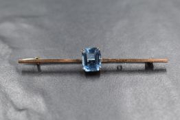 A 9ct gold paste set bar brooch, the blue emerald cut paste in a four claw setting, on a plain