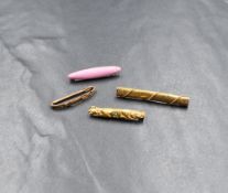A group of four yellow metal bar brooches, one set with a small central turquoise cabochon with