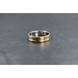 An 18ct gold two tone band, the white gold band having a yellow gold channel decoration, marked 750,