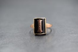 A 9ct gold mourning ring, the rectangular bezel set black panel having a rose gold 'I', with worn