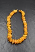 A string of butterscotch amber beads of uneven form having screw clasp, approx 18' & 68.5g