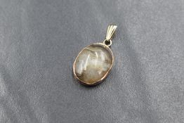 A yellow metal presumed gold agate set pendant, the oval agate cabochon in a bezel setting,