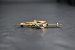 A 9ct gold turquoise set bar brooch, the small bezel set turquoise in an openwork curved setting,