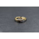 An 18ct gold diamond trilogy ring, having three small diamonds in an illusionary mount with cross