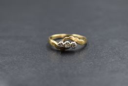 An 18ct gold diamond trilogy ring, having three small diamonds in an illusionary mount with cross
