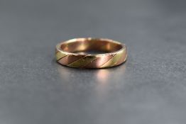 A 9ct rose and yellow gold band, of plain rounded form having alternating bands of rose and yellow