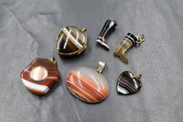 A group of agate jewellery, comprising two carved boot charms, a heart motif locket, an oval