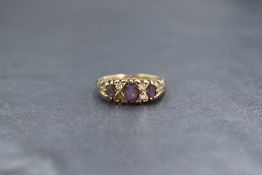 A 9ct gold amethyst and diamond ring having three graduated amethysts interspersed by two pairs of
