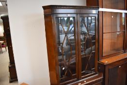 A reproduction mahogany double corner cupboard, with dentil moulded frieze and astragal glazed
