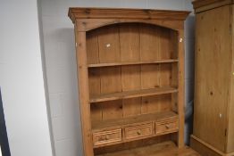 An attractive reclaimed pine kitchen dresser & rack, having a moulded cornice and arched canopy over