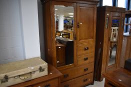 An Edwardian oak two-piece bedroom suite, comprising a gentleman's wardrobe with dentil moulded