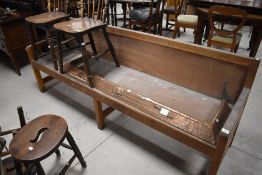 A 20th century oak bench, of typical form with square section supports and slightly shaped arms,