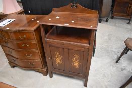 An Edwardian inlaid mahogany music cabinet, having a shallow 'swan neck pediment' over the moulded