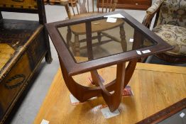 A 1970's teak Astro style glass topped coffee table, of square section with four shaped supports,