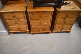 A group of three 20th century pine bedside chests of drawers, each of similar traditional design