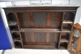 A period oak dresser back having carved decoration to panels, some damage to shelves. Width