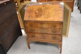A reproduction figured mahogany bureau, of traditional design with fall-front over three drawers
