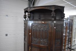 An early 20th century reproduction linen-fold oak hall robe, of canted rectangular form the shaped