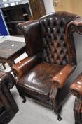 A late 1980's reproduction Chesterfield style deep-buttoned wing-back armchair, of traditional