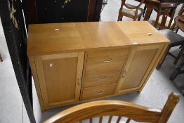 A modern light oak effect sideboard, the oblong top over three central drawers and flanked by