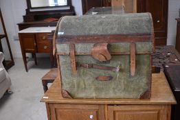 A Victorian green canvas and leather bound woven wicker travel trunk, the arched top lifting to