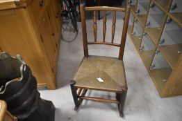 An attractive 19th century rush-seated spindle-back rocking chair, of small proportions, seat height