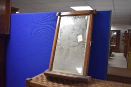 A late 19th/early 20th century oak framed and bevelled wall mirror, of rectangular form, the upper