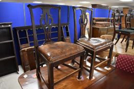 A set of four George III oak splat back dining chairs, having yoke-form top rails over shaped and
