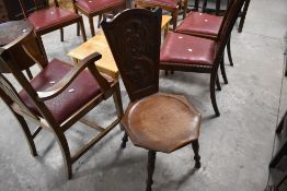 An early 20th century carved oak spinning type chair, the arched back with stipple carved Celtic