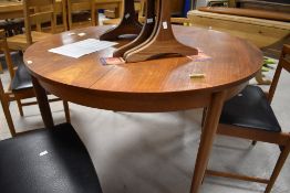 A 1970's teak thought to be G-Plan Fresco circular extending dining table and four chairs, a