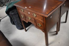 A reproduction mahogany lowboy, the moulded and banded rectangular top above an arrangement of long,