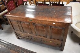 An 18th century oak four-panel mule chest, the planked rectangular top opening on replacement hinges