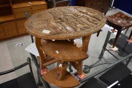 An ethnic/African tribal art style nest of tables, the oval host table carved with figures, the