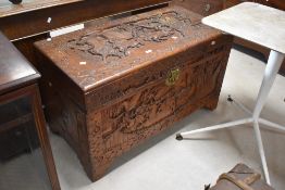 A 20th century Chinese carved camphor wood chest, of hinged rectangular form, carved in relief