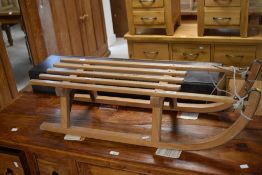 A vintage wooden Davos 90 sledge, of typical railed construction with metal runners 91cm