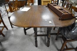 A 1940's oak drop-leaf dining table and four chairs, of traditional design 74cm x 151cm x 125cm,