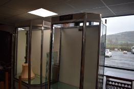 A modern aluminium, glass and grey painted board shop display cabinet, of canted rectangular form